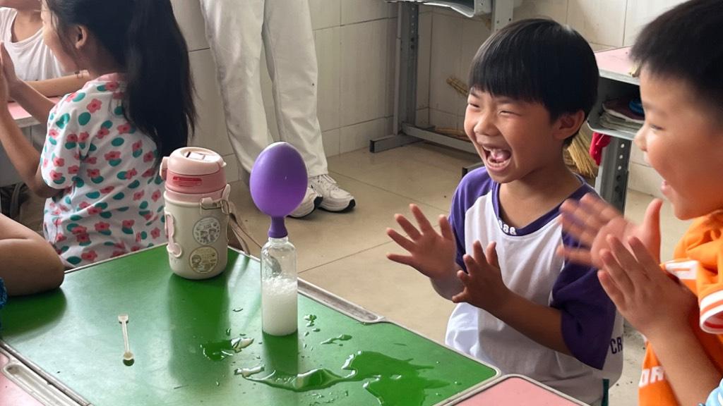 图为学生在自己动手后，看到实验现象后天真烂漫的笑容；此外还有学生通过自己双手做完实验后，为自己鼓掌。