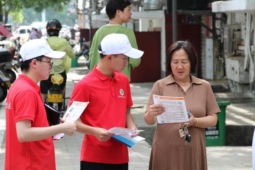 图为志愿者宣讲垃圾分类知识，鼓励居民参与到垃圾分类行动中来。 刘欣 供图