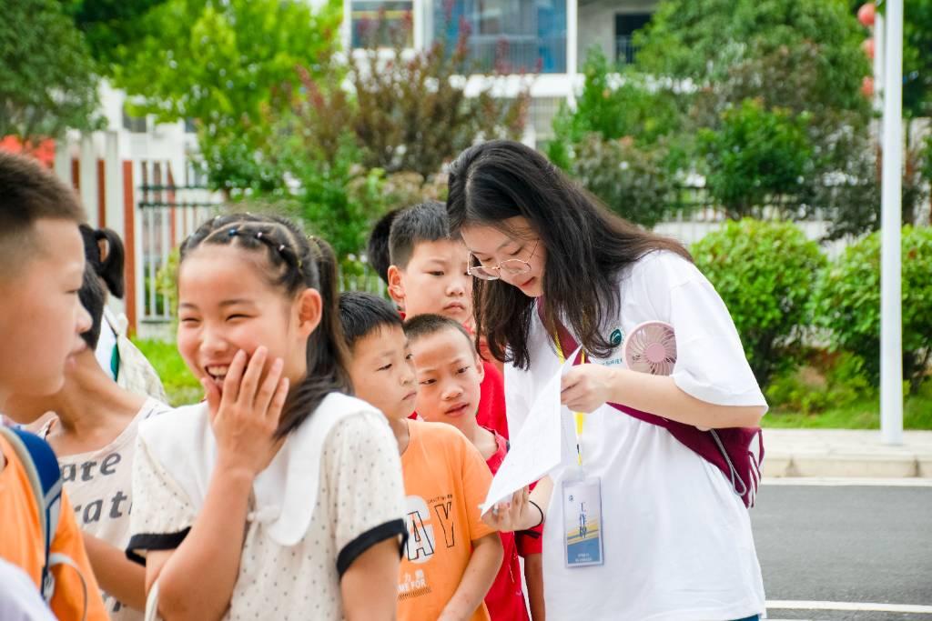 队员核对学生信息，与学生亲切交谈，助力学生开启精彩暑假生活