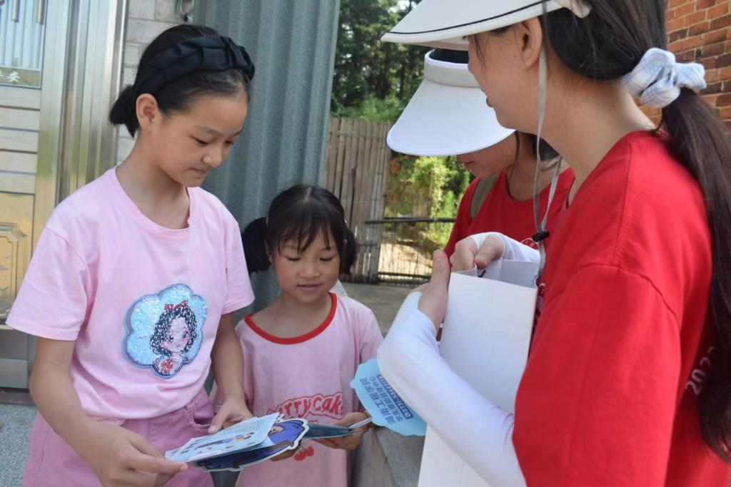 04实践团成员向当地孩子介绍国家资助政策。湖南工程学院骆媛提供