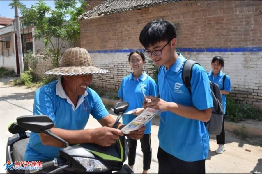 图为实践队员在街头普及乡村振兴知识