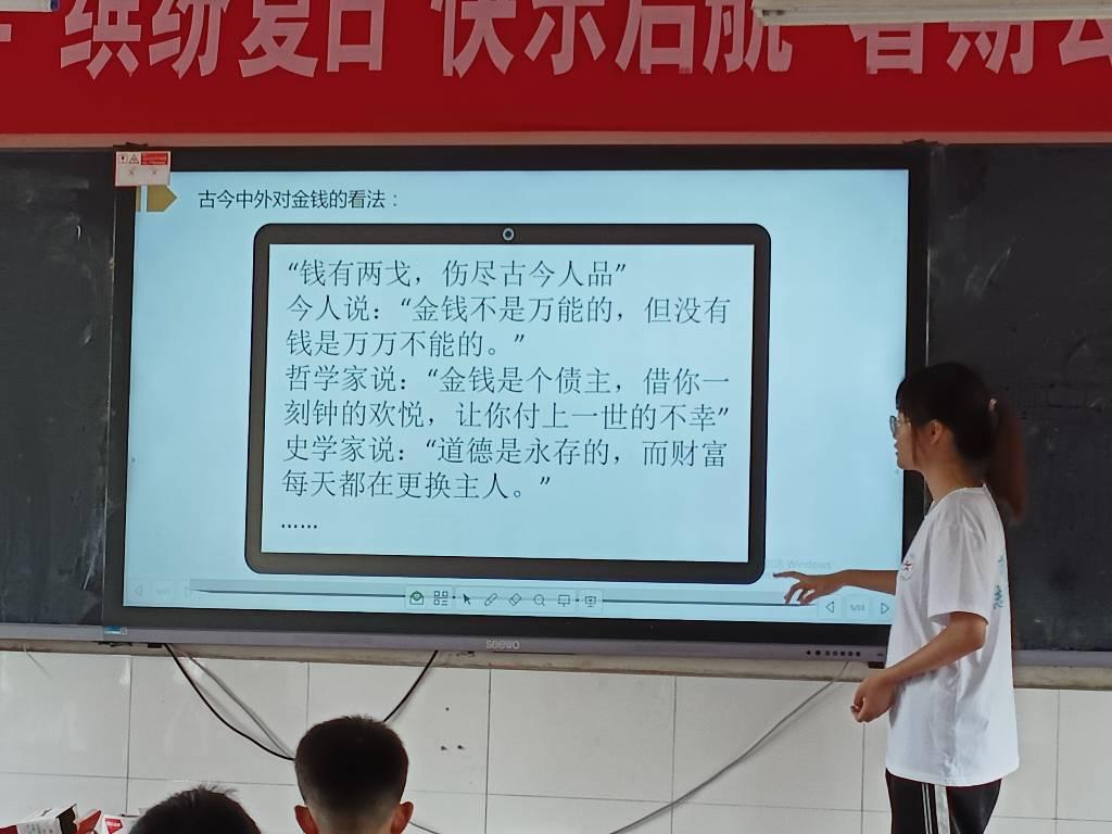 图为志愿者给学生讲解如何培养正确的金钱观念，教给学生正确的金钱理念和正确的金钱价值观。大学生网报通讯员 王曼昕供图