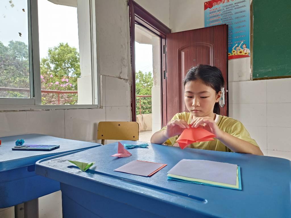 图为手工折纸课上，学生认真学习志愿者讲解的课程，学生的积极性都非常高，志愿者与学生的互动非常多，课堂上充满了欢声笑语。大学生网报通讯员 王曼昕供图