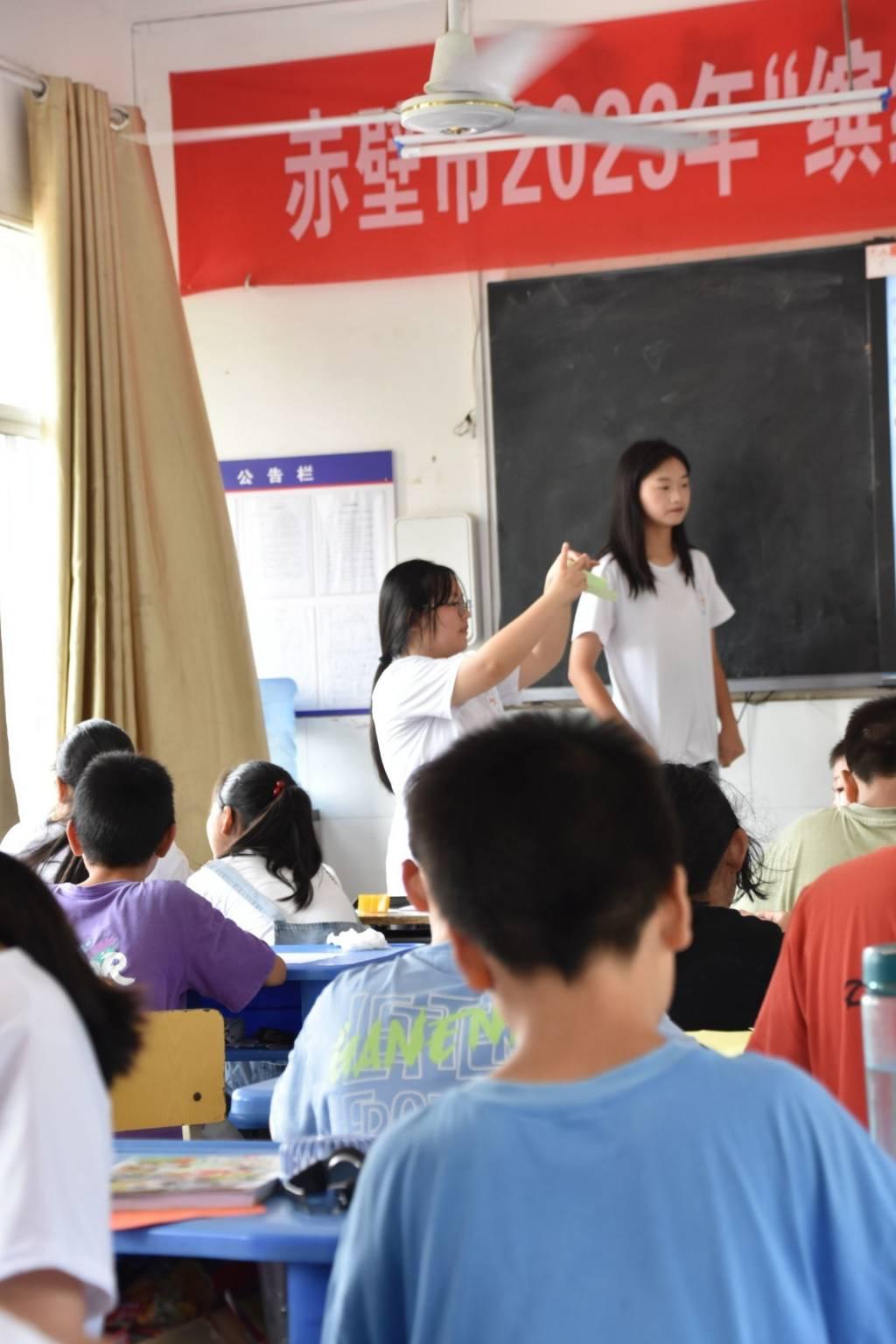 图为手工折纸课上志愿者教学生折纸，难度相对较高，但是学生都学的非常认真，有不会的地方会积极的询问志愿者。大学生网报通讯员 王曼昕供图