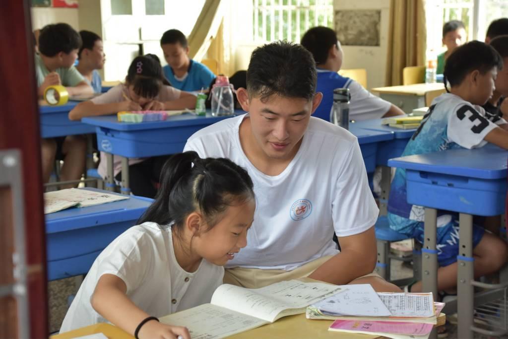 图为志愿者辅导学生的暑假作业，经过几天的辅导，学生每天都能记住前一天的知识，并且掌握当天的知识。大学生网报通讯员 王曼昕供图