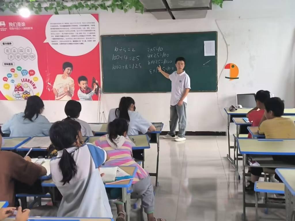 图为团队成员为学生上数学课。由团队成员为他们讲解一些数学知识和在作业中遇到的问题。