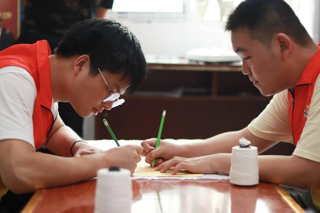 图为实践队在叙永县白腊苗乡扎染小作坊练习扎染的第一个步骤—画。朱春艳 摄