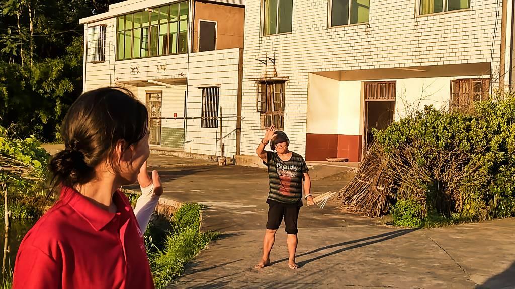 挥手，再见 图为朝阳实践团采访完油纸伞手艺人谭奶奶后，谭奶奶依依不舍地与朝阳实践团告别 杨琴 摄