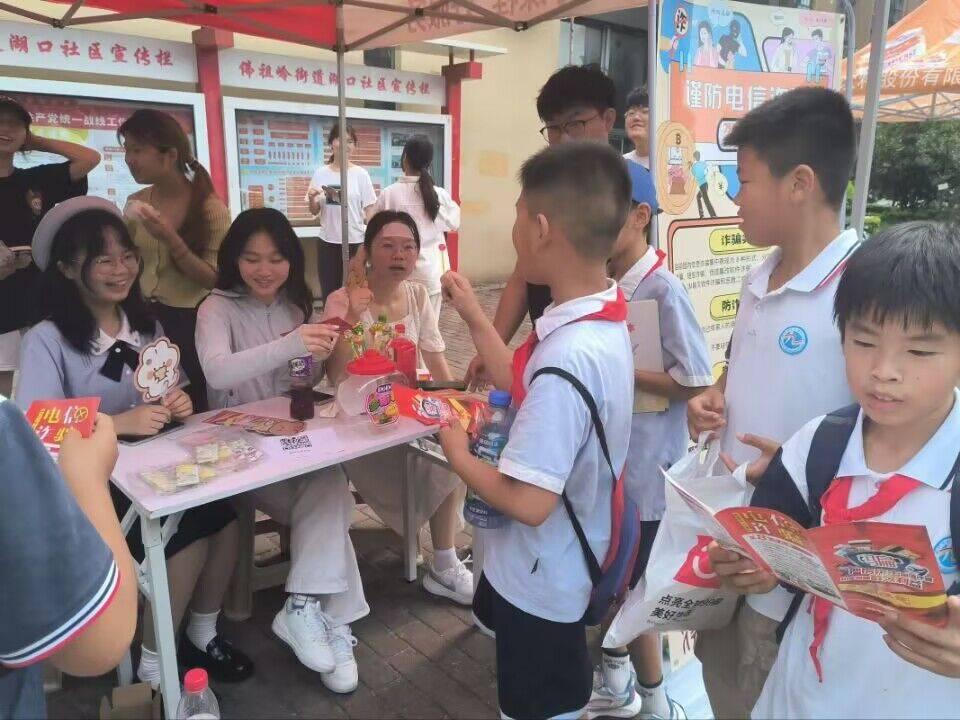 图为小朋友与队员们讨论关于电信诈骗的危害。 中国大学生网报通讯员 刘鸿旺 提供