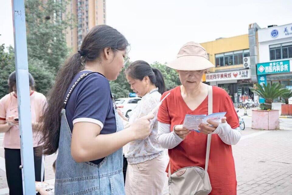 图为队员在给社区居民讲解宣传手册上的内容。中国大学生网报通讯员 刘鸿旺 提供