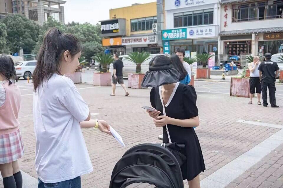 图为团队成员邀请社区居民填写关于党史了解的电子问卷。 中国大学生网报通讯员 刘鸿旺 提供