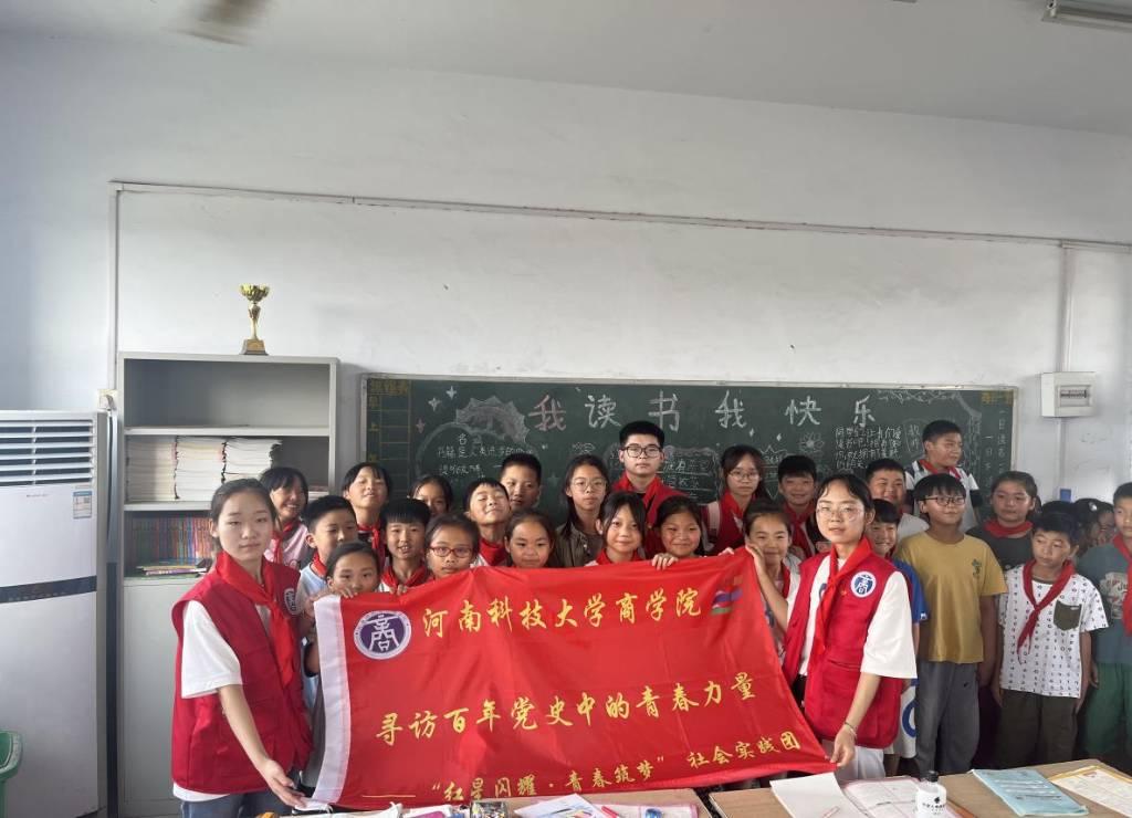 图为实践成员与学校教职工和小学生合影