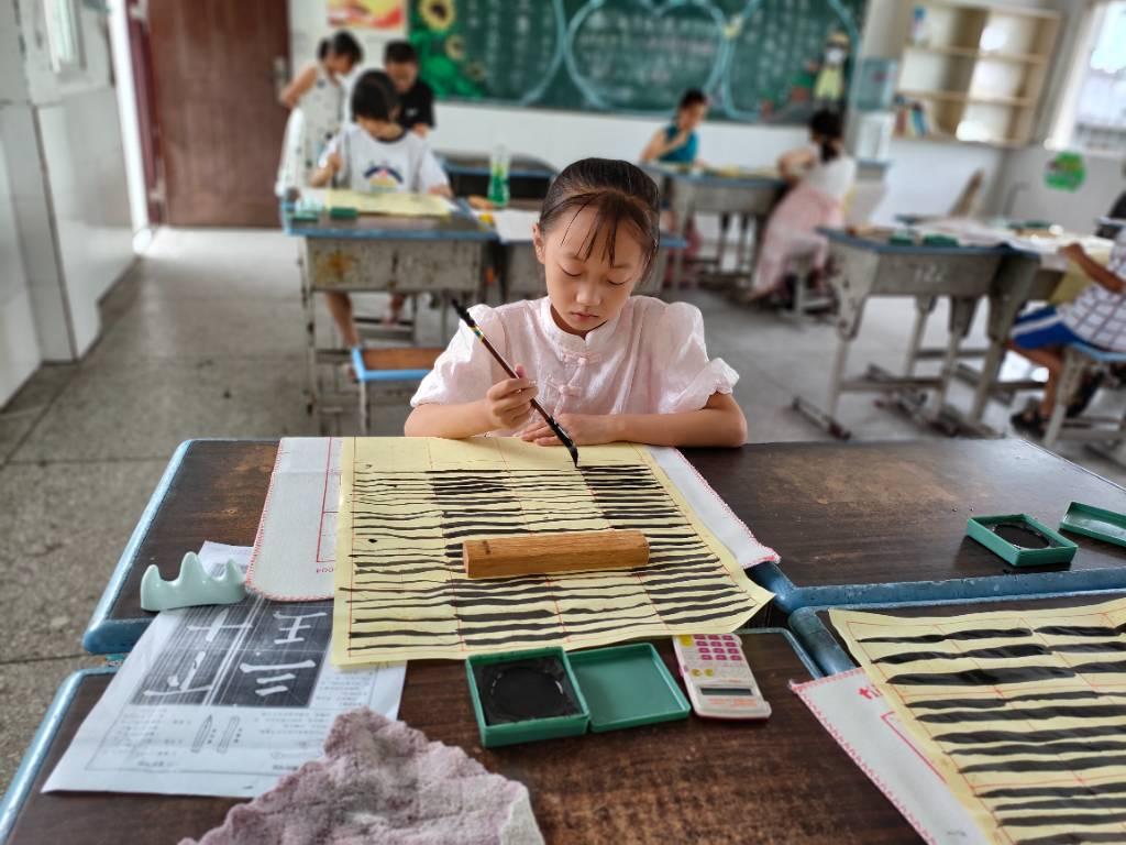 在老师认真授课书法课后，学生按照老师的要求，认真进行书法练习，完成课堂作业。