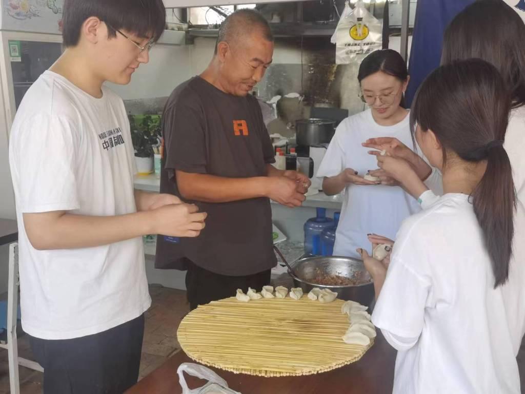 “寻访·探忆·筑梦”实践团在河北省承德市双桥区冯营子镇砖瓦窑村村民家，与村民一同包饺子。