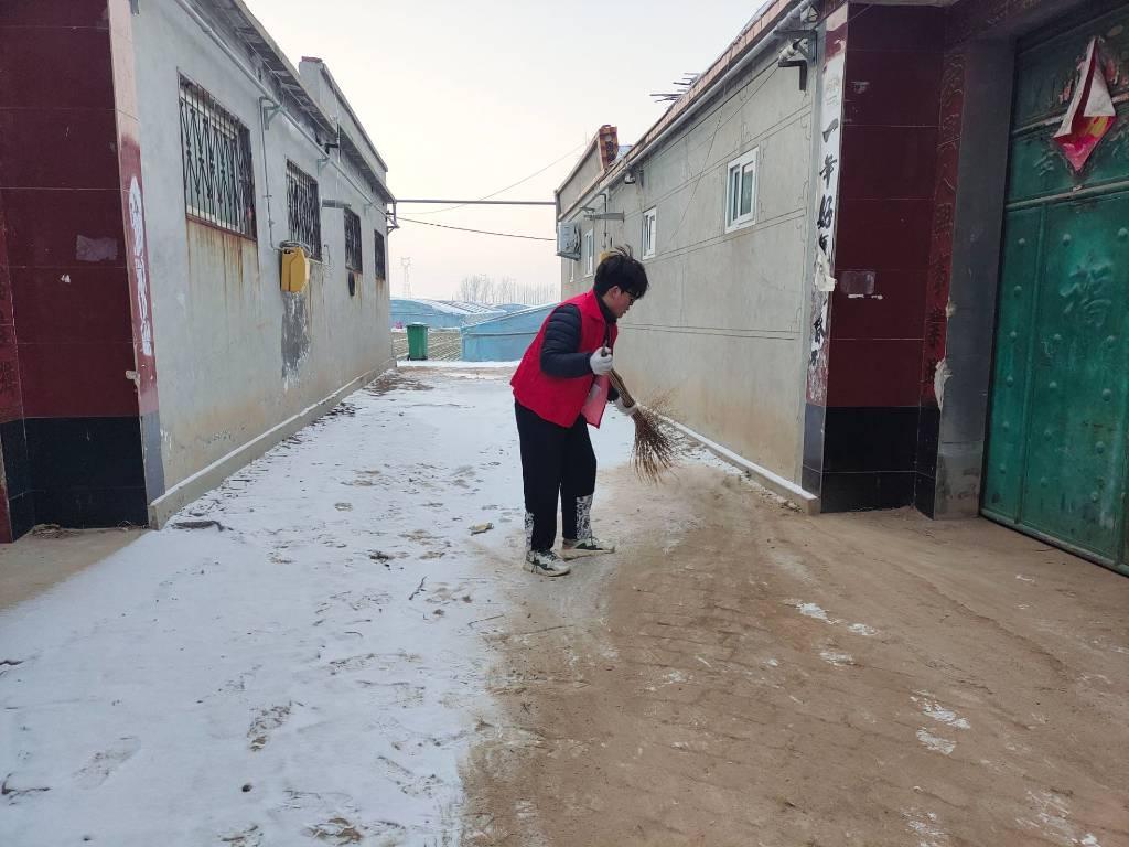 图为“践行时代信仰，传承精神火炬”实践队队员在扫雪。