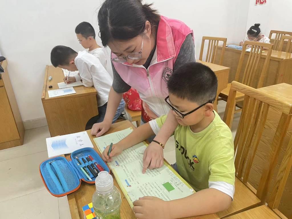 图为班主任老师在辅导小朋友的暑期作业 大学生网报通讯员邵元珽摄