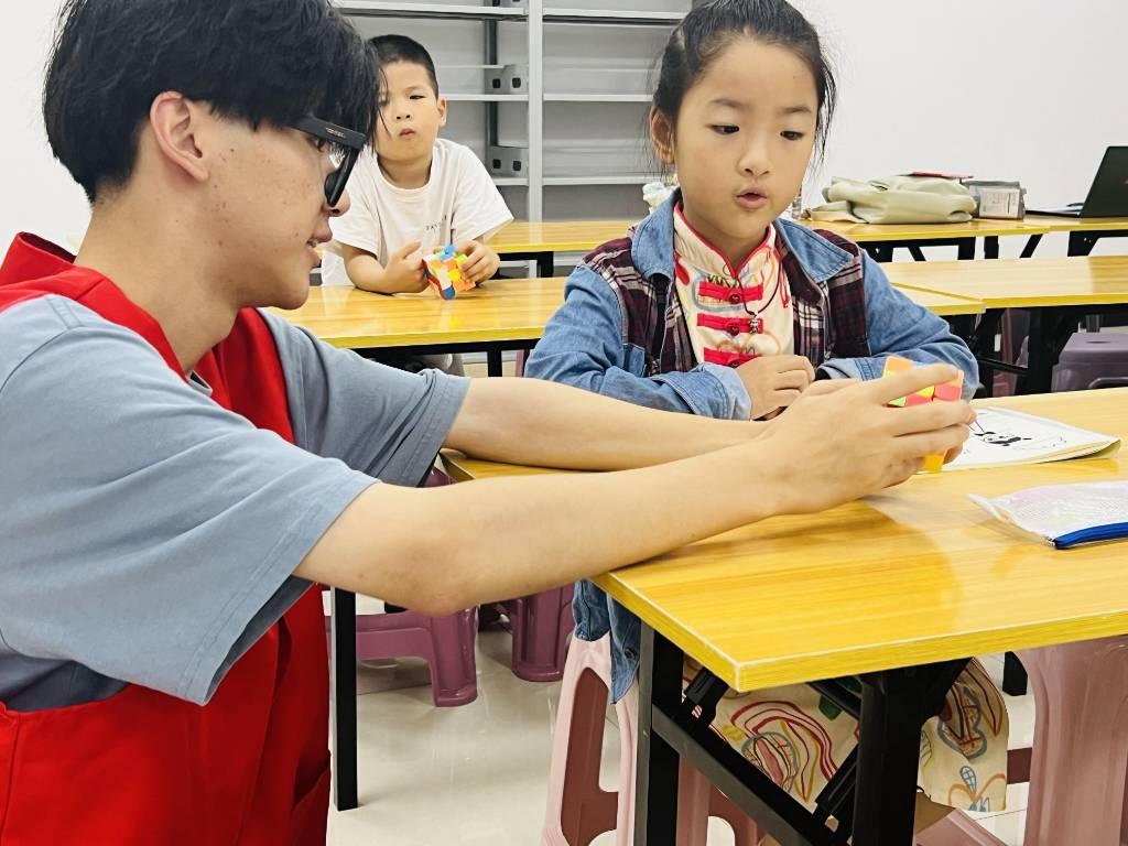 图为志愿者老师在进行魔方教学 大学生网报通讯员邵元珽摄