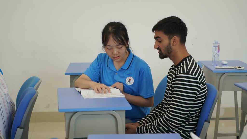 图为实践人员阳萍丽教留学生正确的汉字读音。