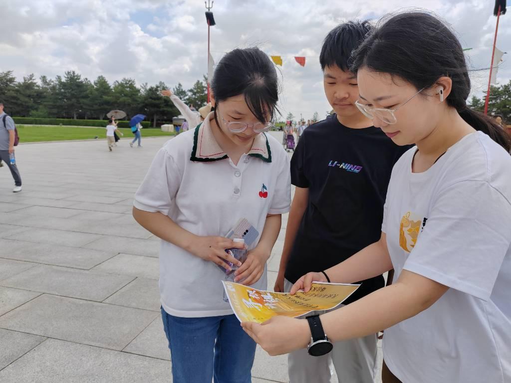 图为团队成员在成陵采访中学生。