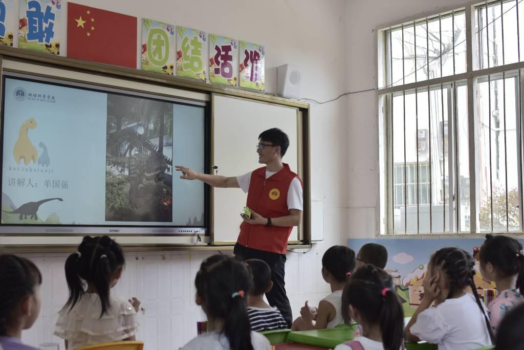 （图为团队成员给孩子们科普恐龙相关知识。）单国强摄