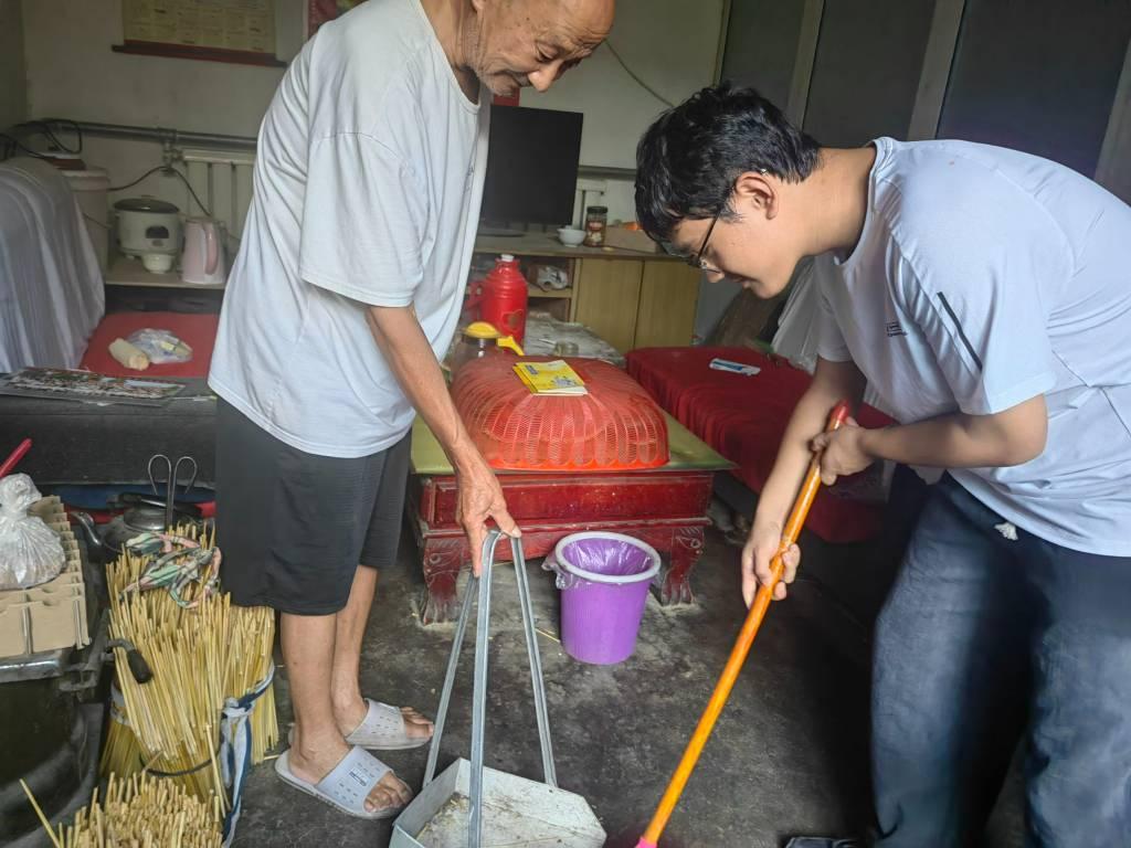 图为，与老党员一起劳动，和老党员一起整理这间屋子，拉近与党员距离。 中国青年网通讯员 沙世琪 供图