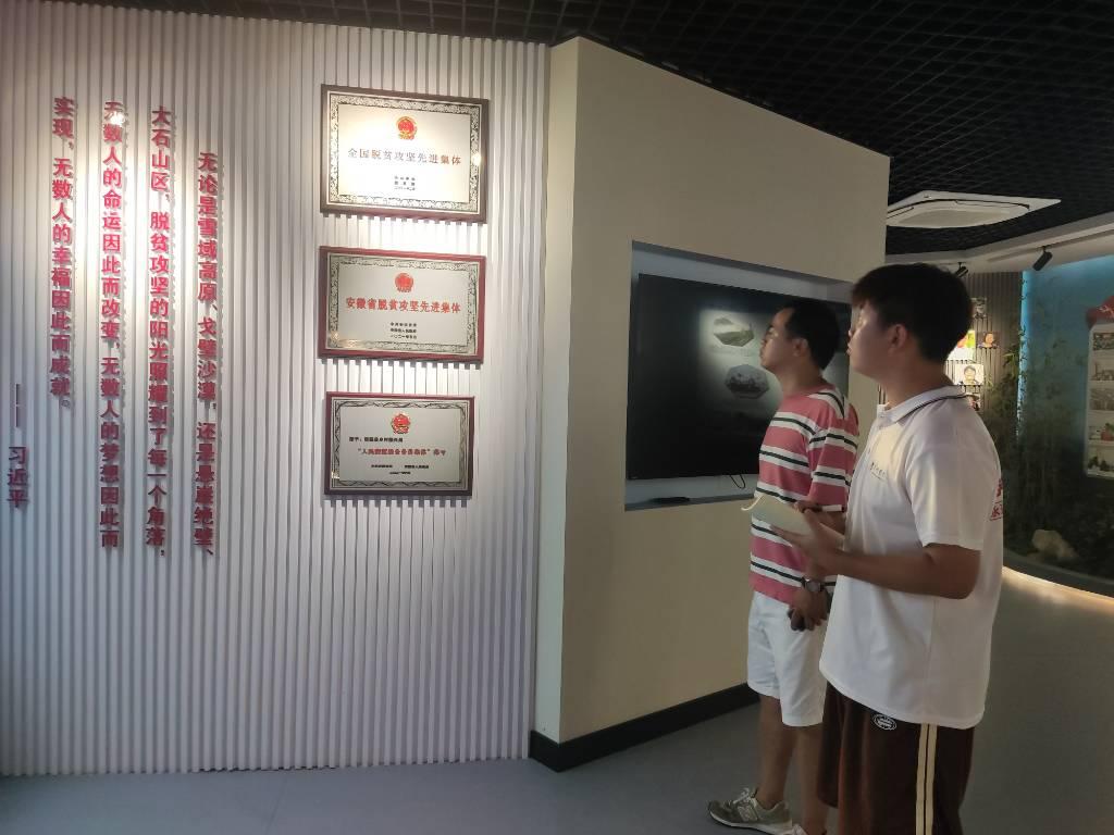 图为实践团队成员在记录小康工程展馆在观看乡村振兴发展成果。