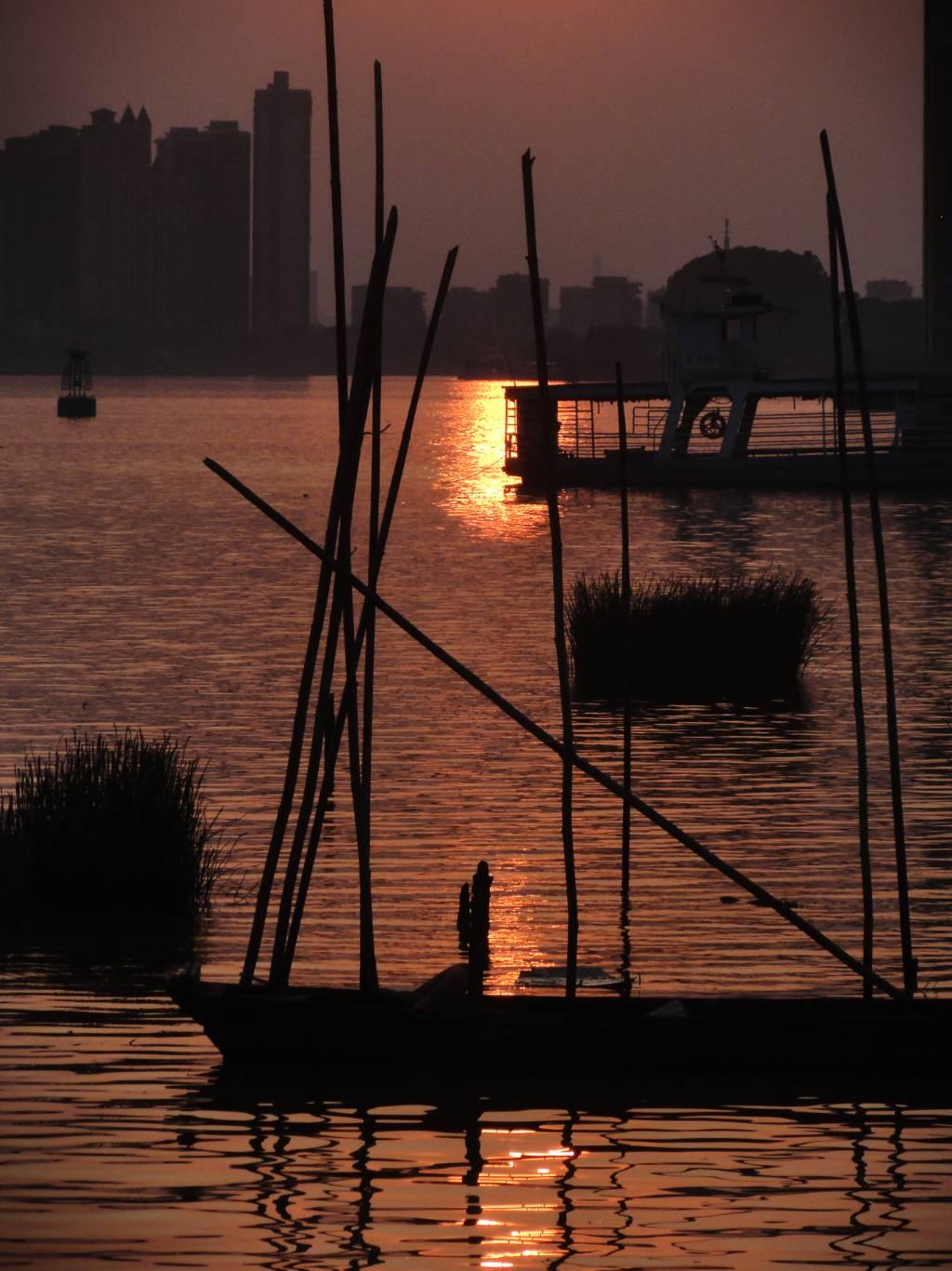 夕阳西下，船只在水面上，与夕阳倒影相得益彰，景象宛如仙境。