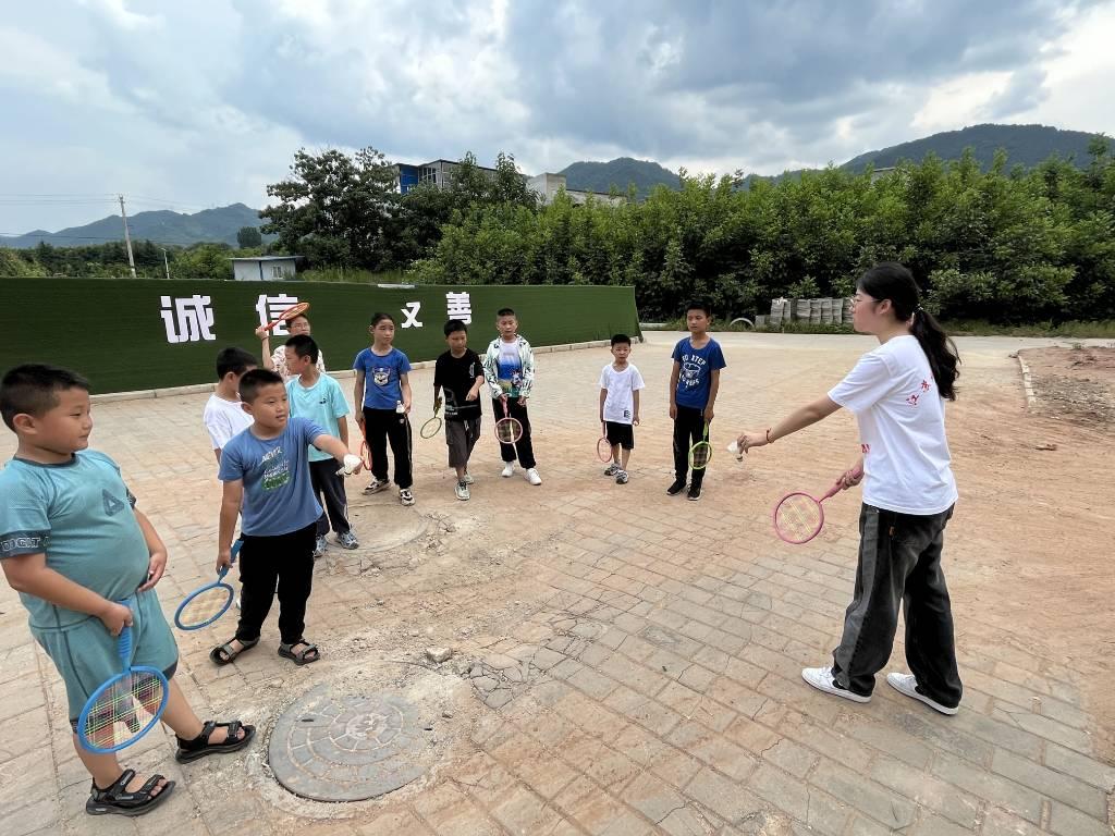 “苏秦懿行”队员在教小朋友们羽毛球的挥拍姿势。