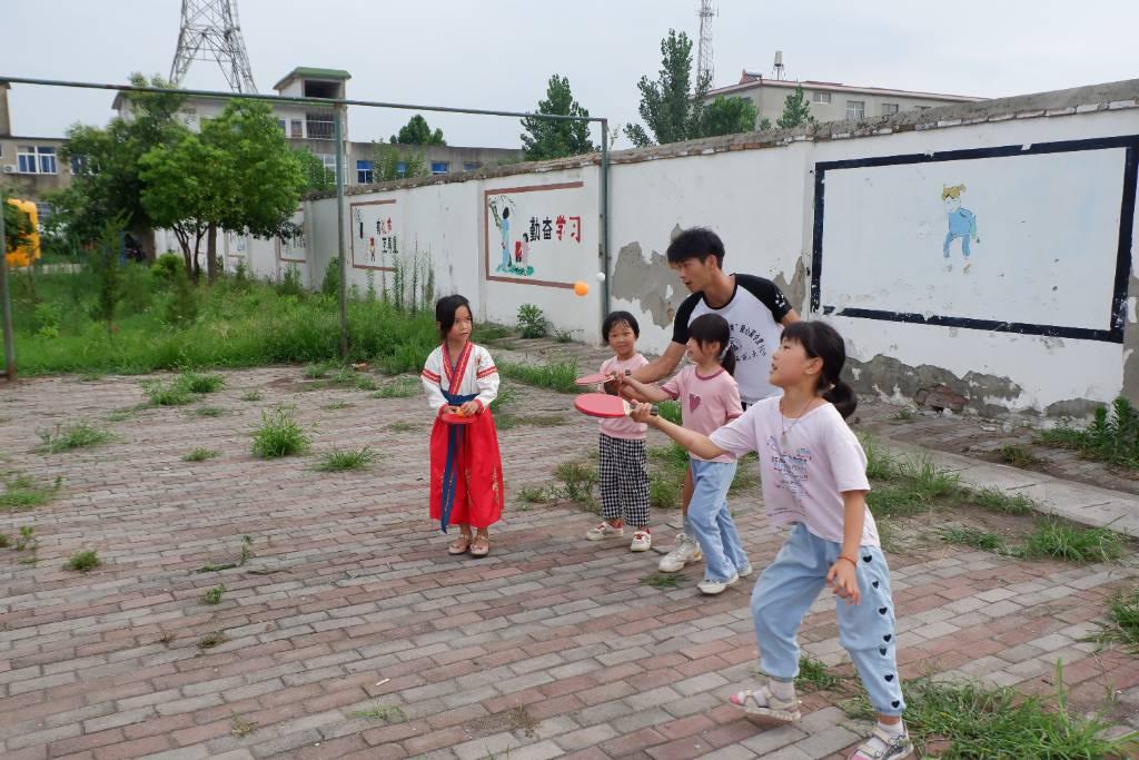 图为体育课上老师亲自指导孩子们打乒乓球。中国青年网通讯员 李鑫 摄