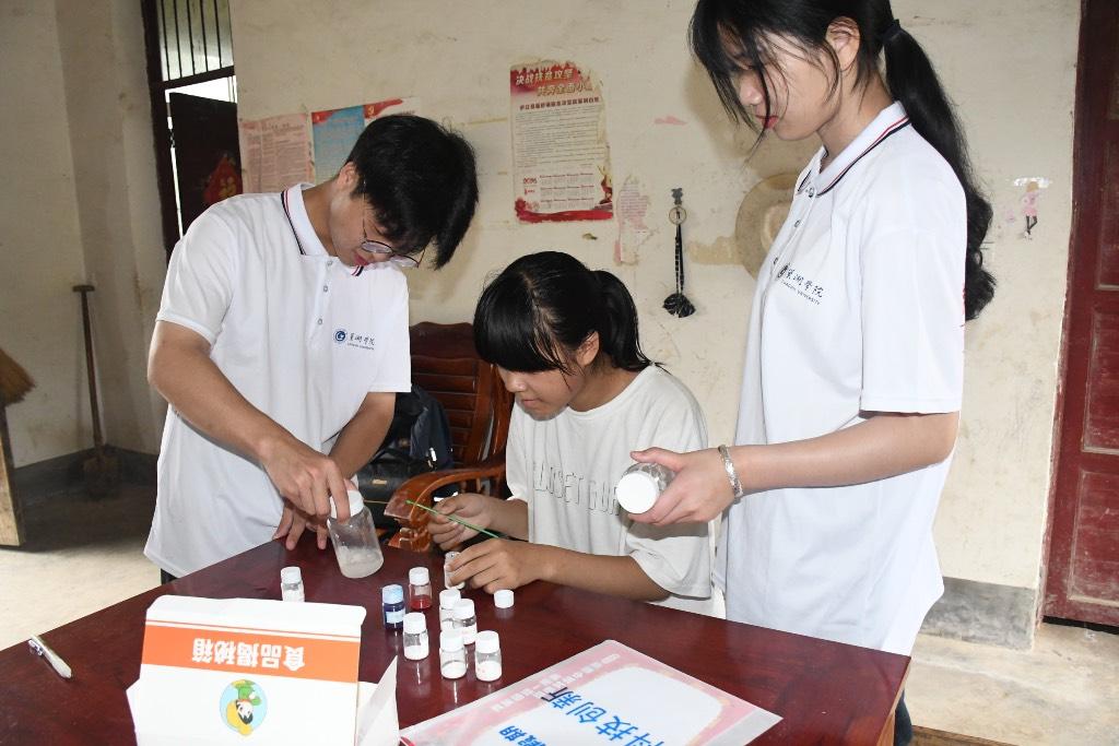 图为志愿团队成员和小朋友一起做简单的食品化学实验