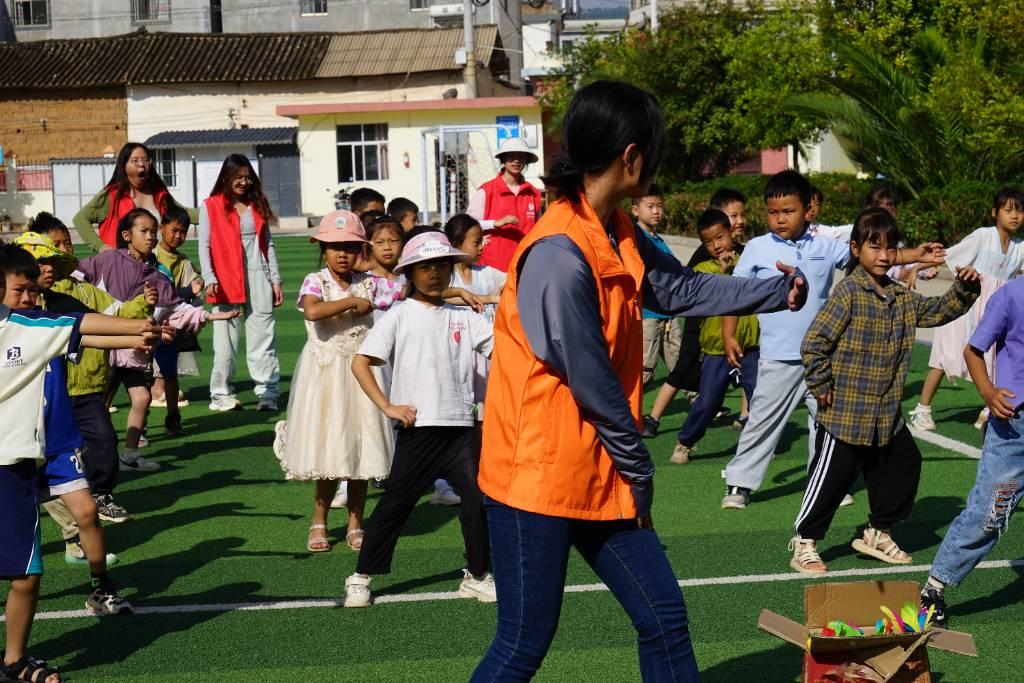 图为“石榴籽”民族团结实践团志愿者在操场上教小学生们学习二十四式太极拳。（玉溪师范学院文学院“石榴籽”民族团结实践团 供图）