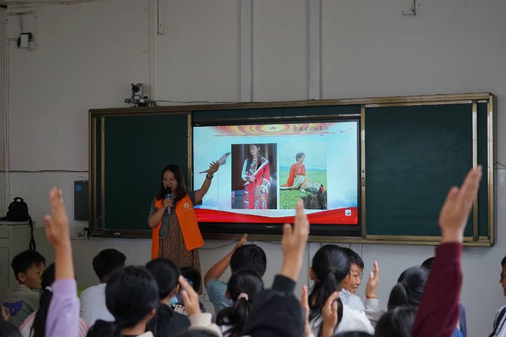 图为学生参加民族知识竞赛答题环节踊跃举手的画面 （通讯员 李卫灵摄）