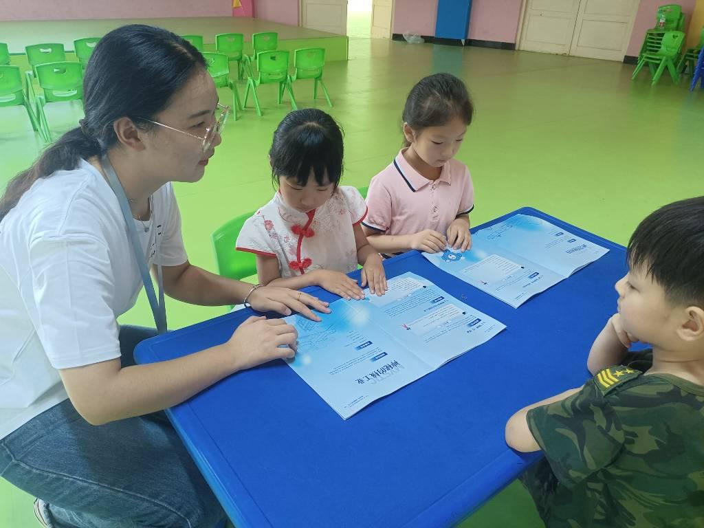 宣讲团成员带领小朋友提前观看学习宣传册预热