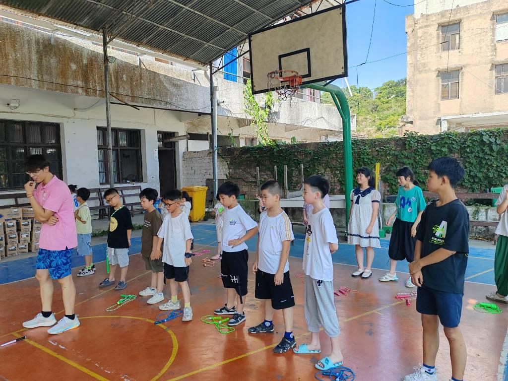 图为实践团成员带领小候鸟们做热身运动。陈茵摄