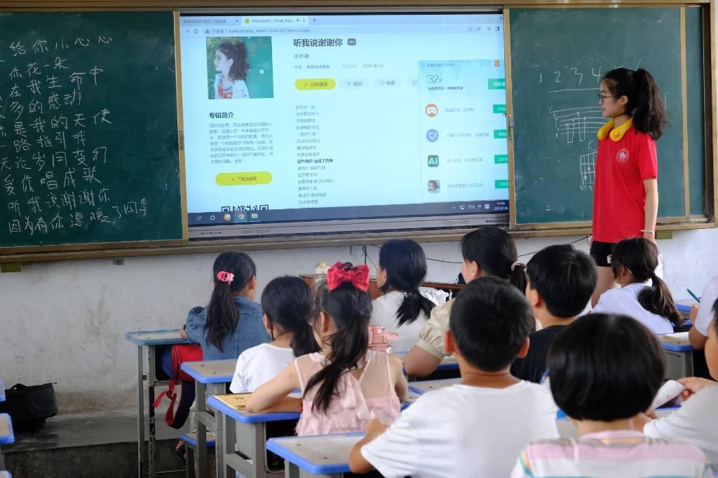 图为志愿者在重渠小学结合经典童歌，给孩子们科普简单乐理知识。