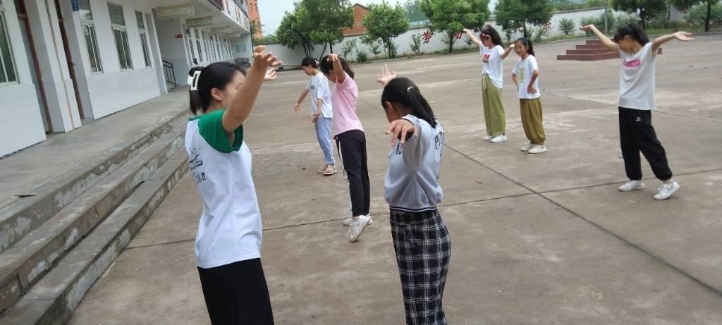 图为萤光支教团舞蹈老师陈荣灵带领学生跳舞的场景。