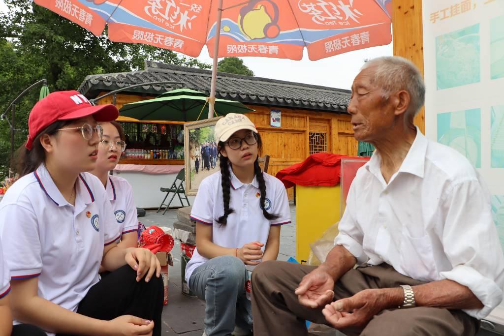 图为实践队员与大湾村村民交流“大别山精神”的传承。