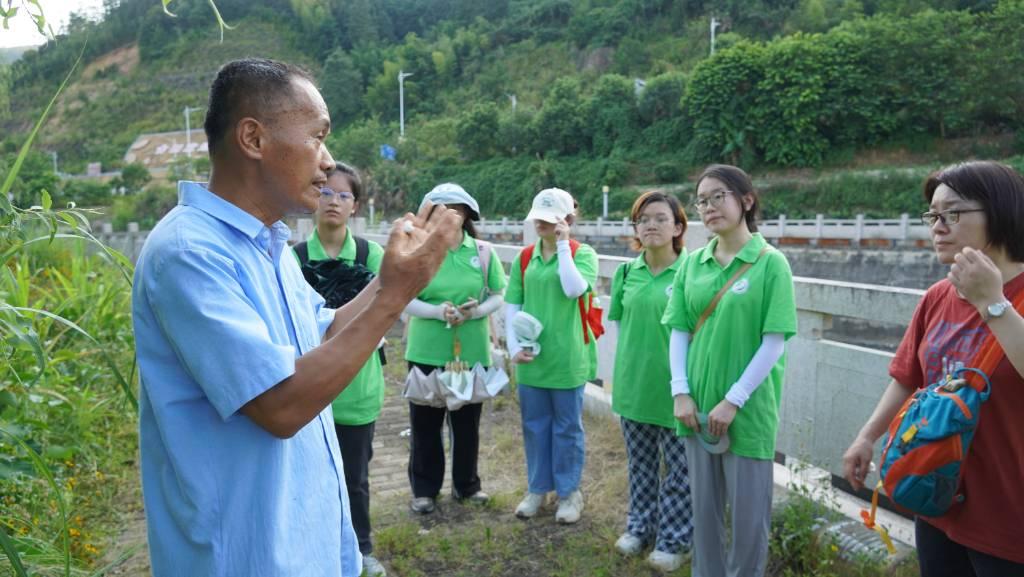 2023.7.9 林老师在给实践队员们讲解在洋上村他正在做的土地种植实验——嵌套种植。