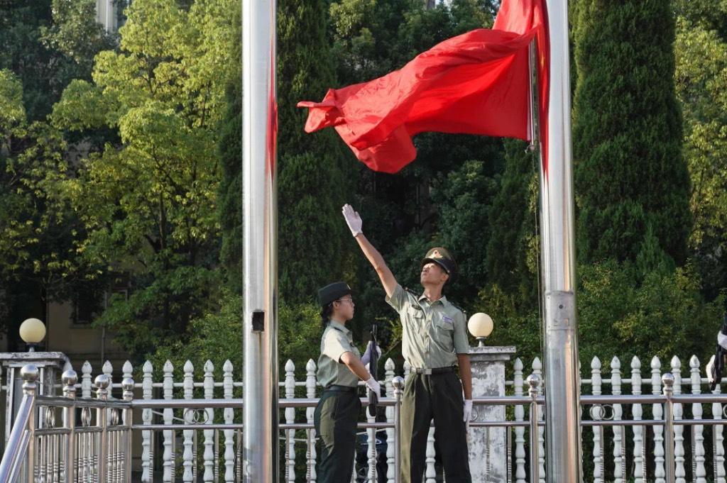 学校国旗护卫队庄严的进行升旗仪式，五星红旗冉冉升起