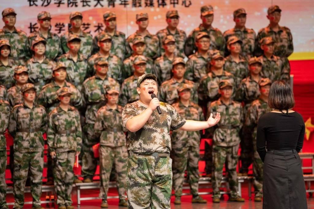 男生深情演唱着：“当那一天真的来临，在祖国需要之时，我们愿随时奔赴战场，若有战，召必回，清澈的爱，只为中国”