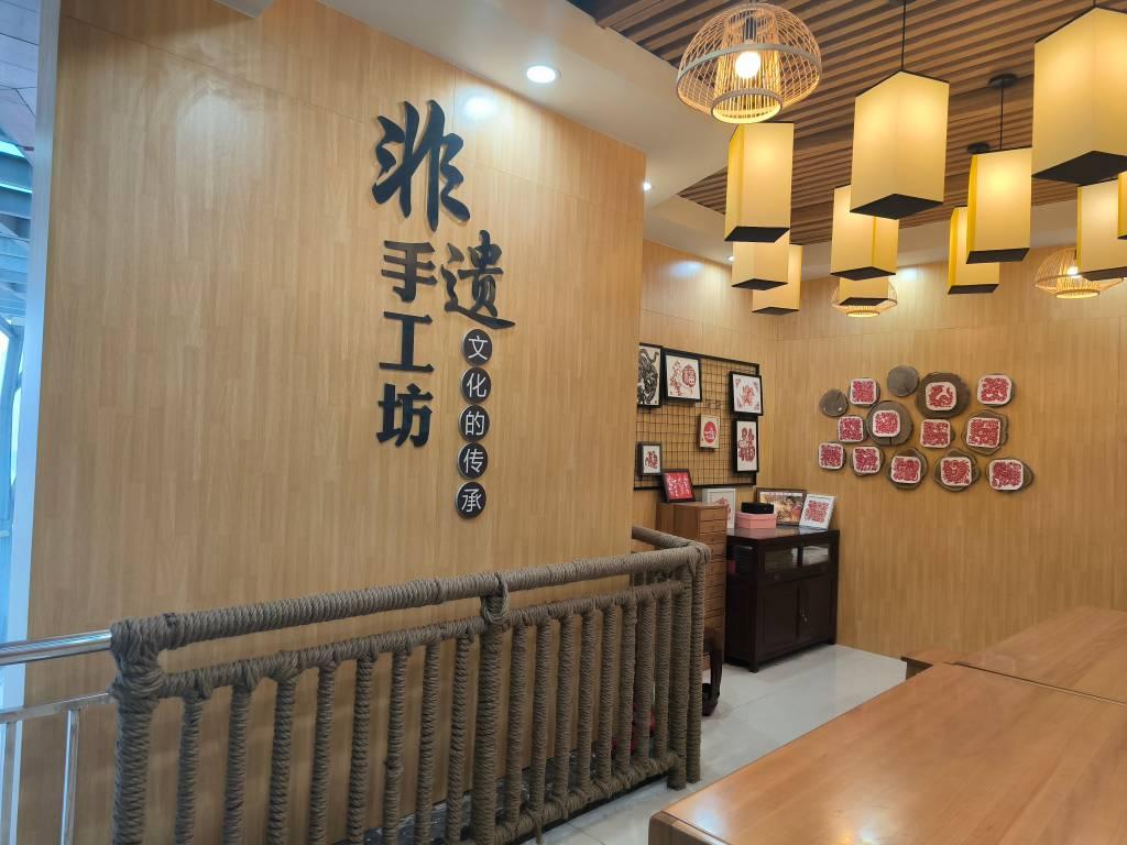 此为位于胶州市文化馆内的非遗手工坊——胶州剪纸展览区。展区内有造型精美、题材多样的剪纸作品，大部分为胶州剪纸传承手艺人所作。