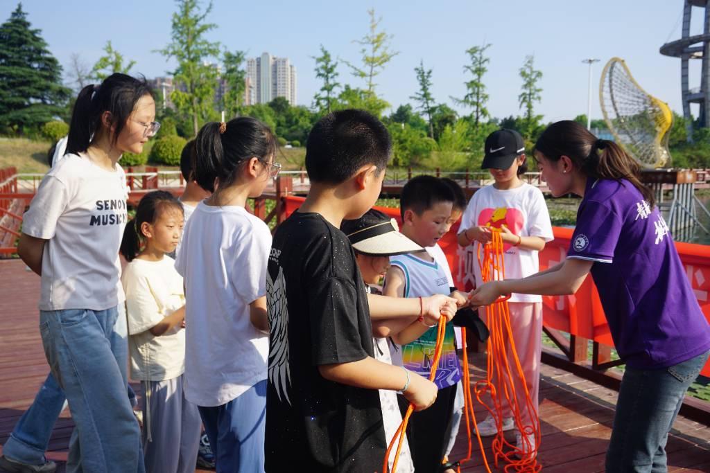 图为团队成员马俊竹手把手教导儿童抛投救生绳。魏欣悦摄