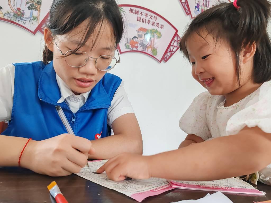 图为志愿者和小朋友在做游戏。 湖北工业大学 谭倩 摄