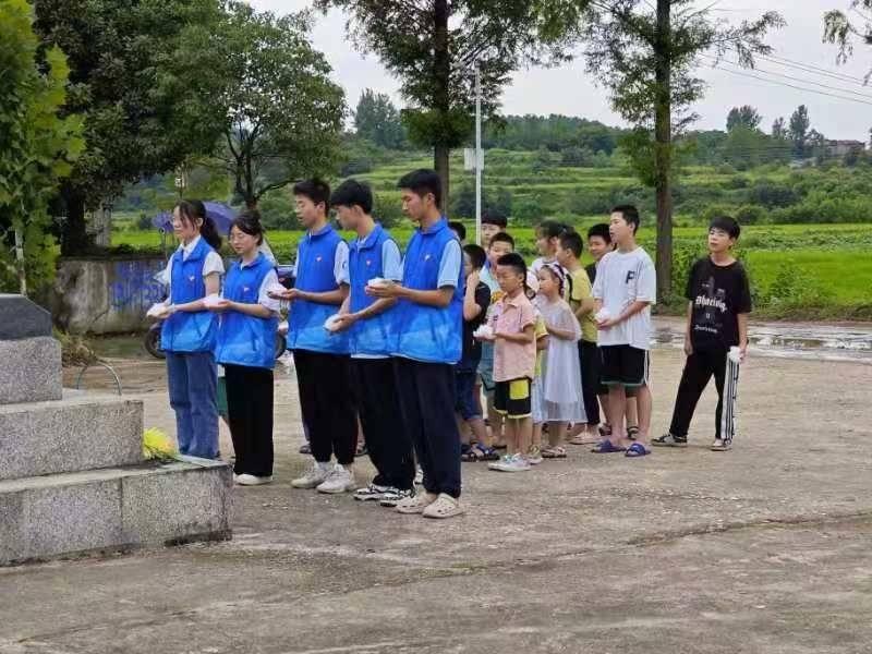 图为志愿者们和小朋友们捧着纸花。复兴村村委会 提供