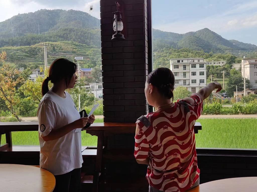 图中为农家乐老板娘为团队成员详细介绍錾子石特色产业的发展，并指出这些特色产业的发展更好的吸引游客前来体验乡村风情。