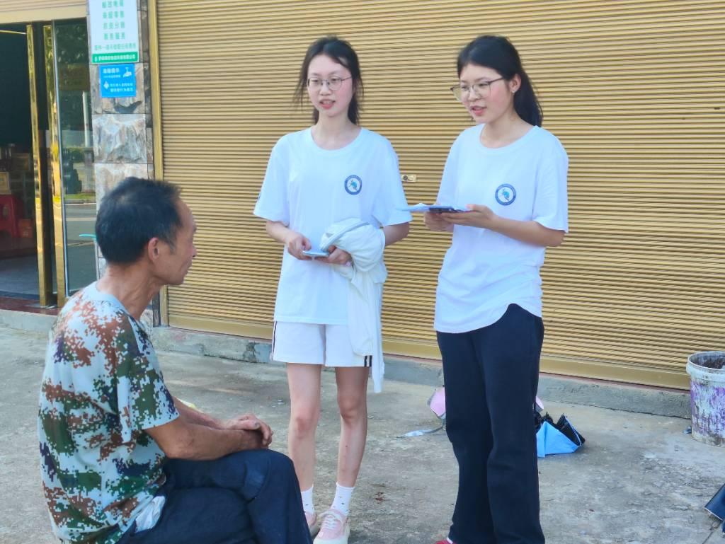 图中为村中居民给团队成员介绍当地旅游发展的一些进程。