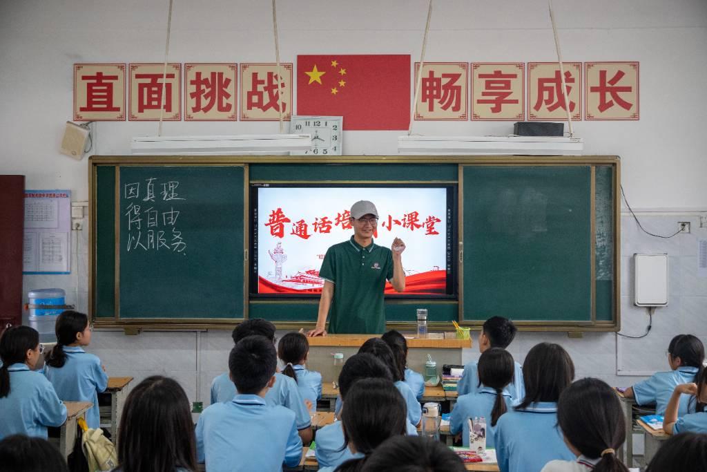 图为团队成员在学校向青少年学生普及普通话的重要性及学习普通话方法的宣讲活动。