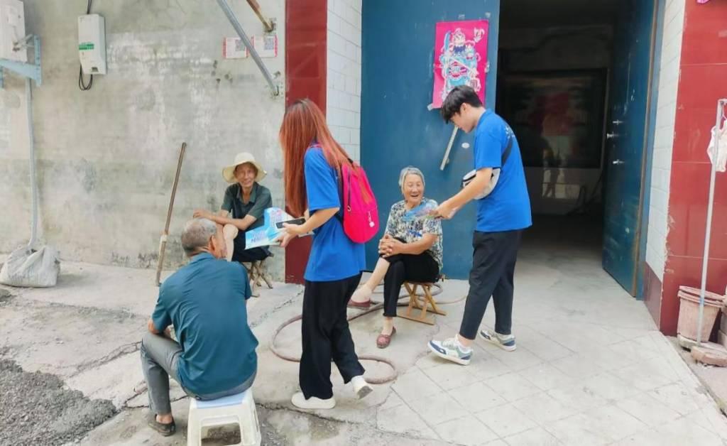 图为实践团成员向居民讲解宣传册内容，村民认真聆听，积极与实践团成员互动