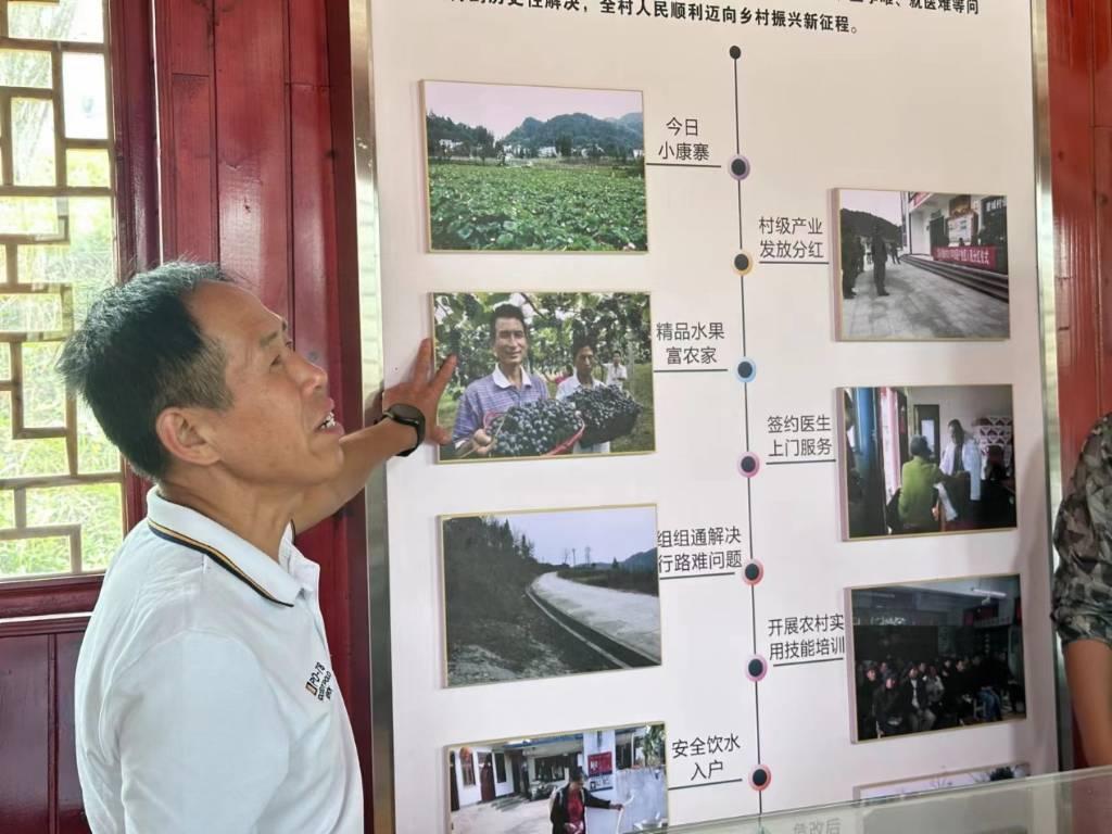 图为村支书向实践小队介绍望城村过去到现在的乡村产业发展和乡村变革。