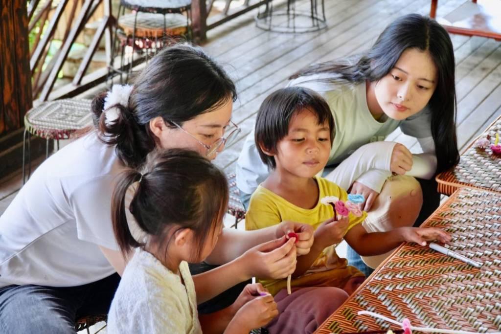 实践促进团成员们正在指导老达保村的孩子们制作花环。